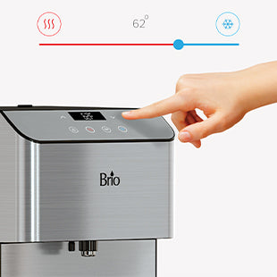 A hand presses a button on a stainless steel Brio water dispenser. The display shows a temperature of 62°F, with icons indicating hot and cold water options above the dispenser.